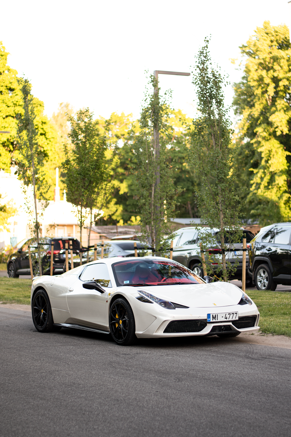 a white sports car parked on the side of a road