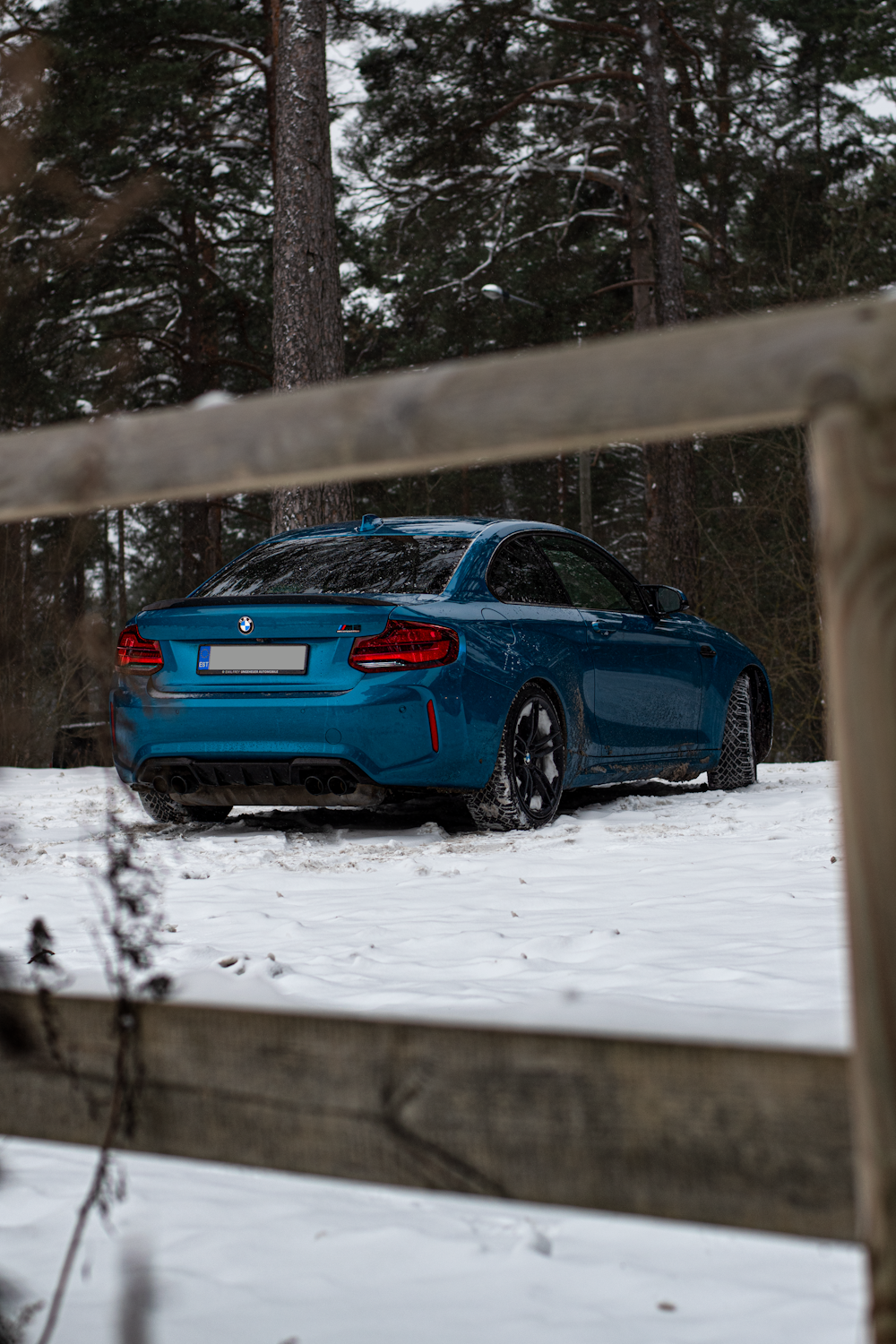 a blue car parked in the snow