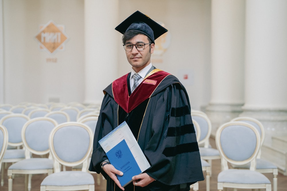 a person wearing a graduation cap and gown holding a diploma