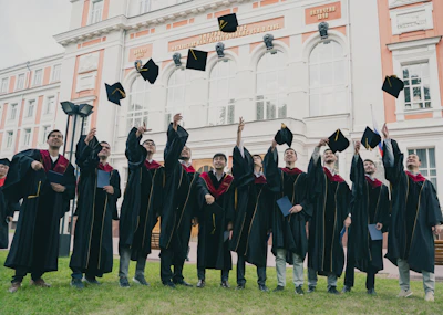 Students celebrating their graduation day with caps in the air