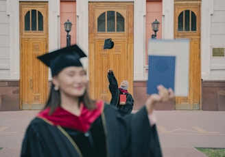 a woman in a graduation cap and gown with a cat on her head