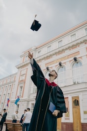 a person in a robe holding a gun in front of a building