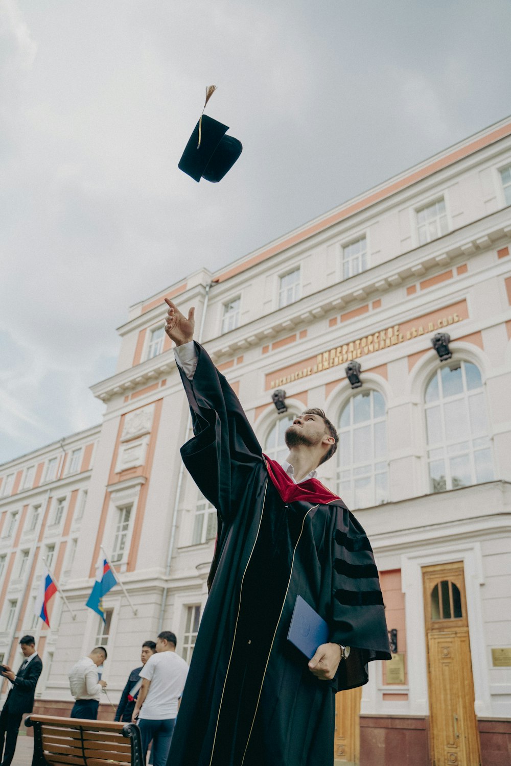 a person in a robe holding a gun in front of a building