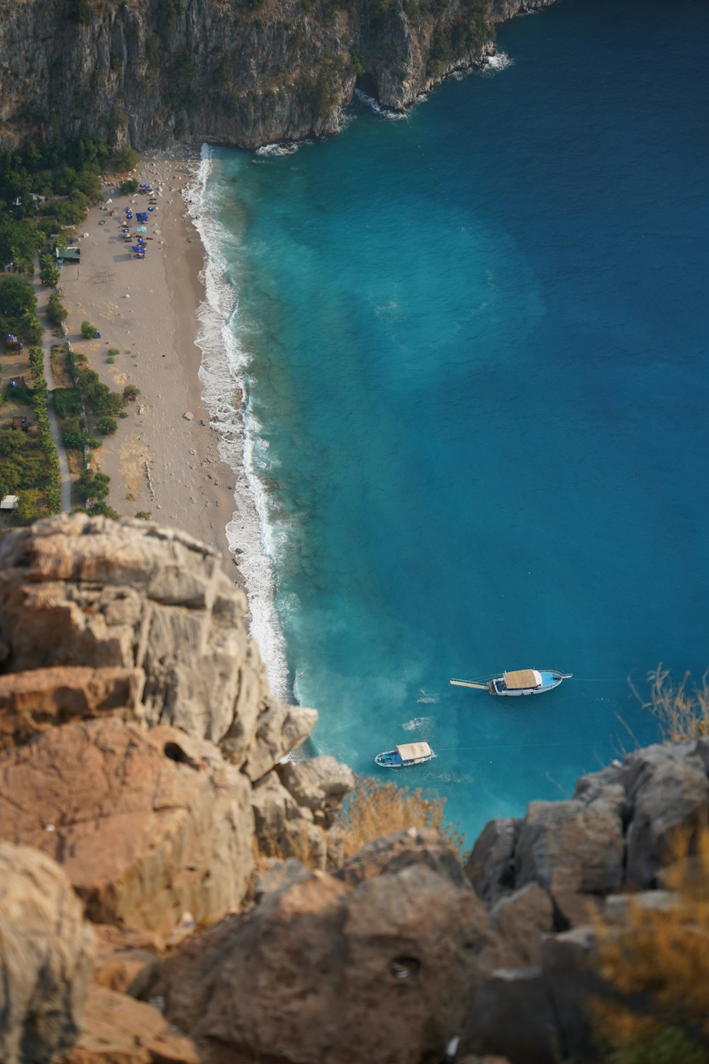 a beach with boats and people