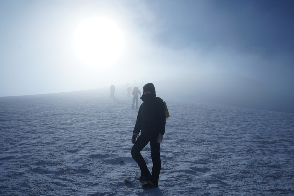 a group of people walking on a snowy field