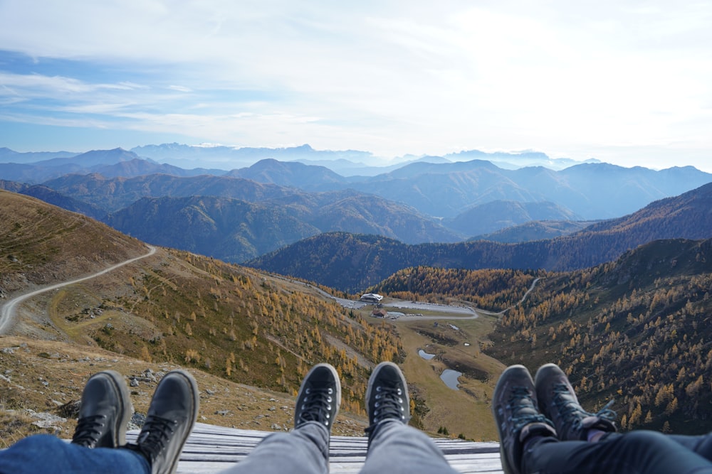 a group of people sitting on a ledge overlooking a valley