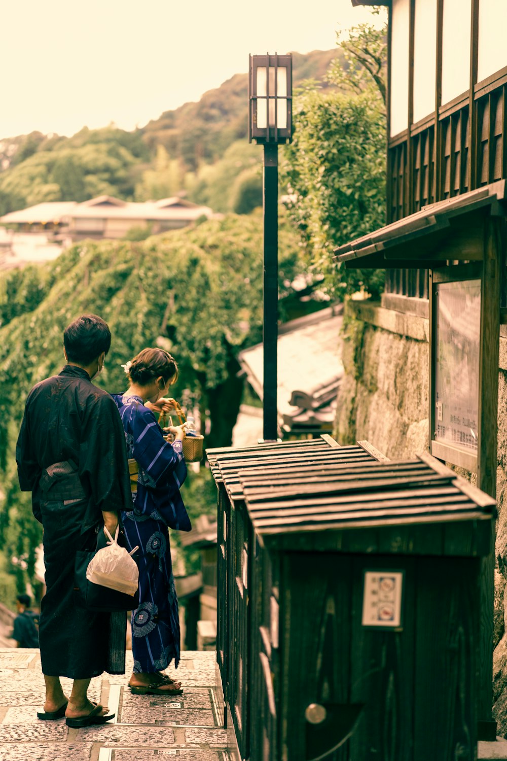 a man and woman standing on a sidewalk looking at a street light