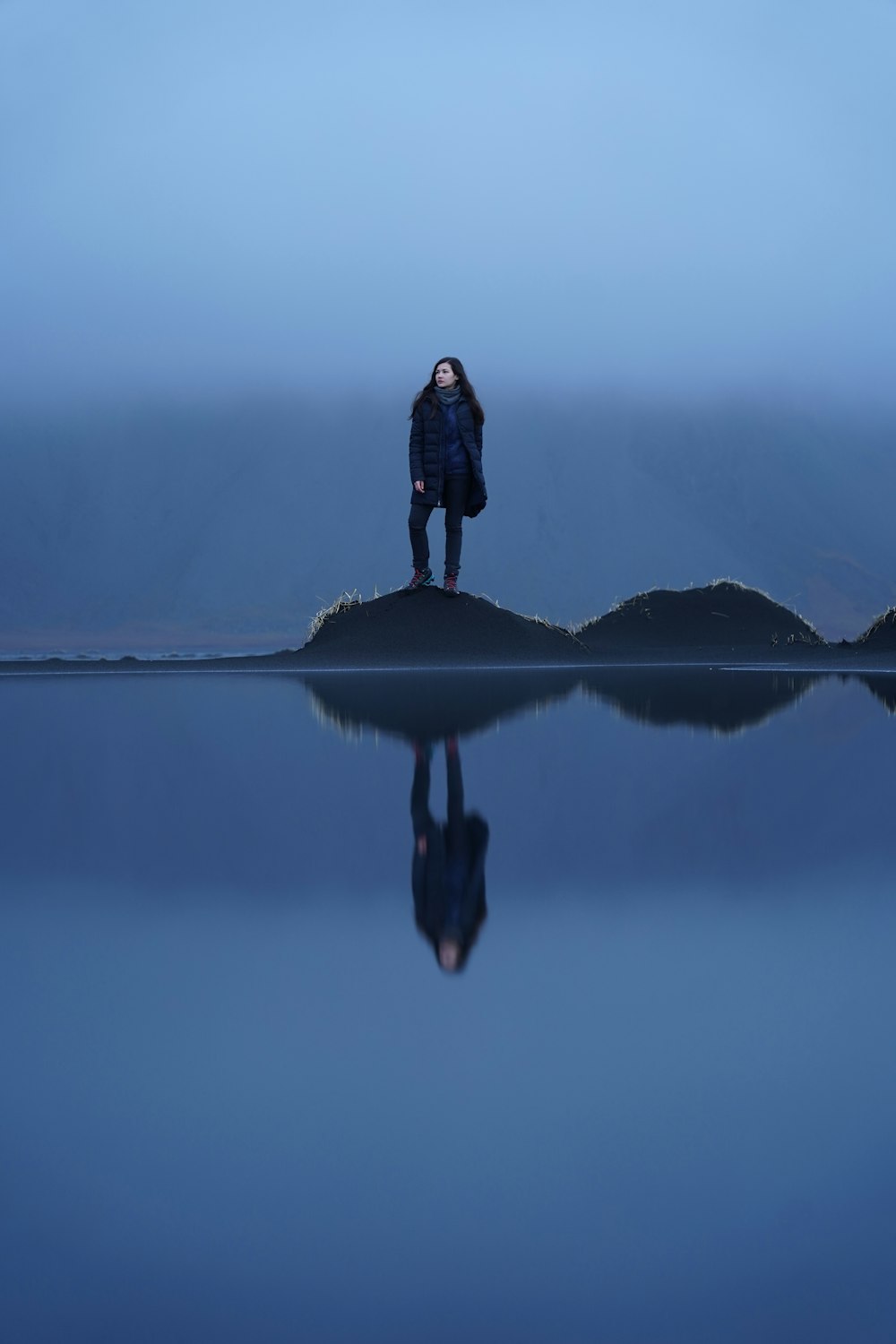 una persona in piedi su una roccia nell'acqua