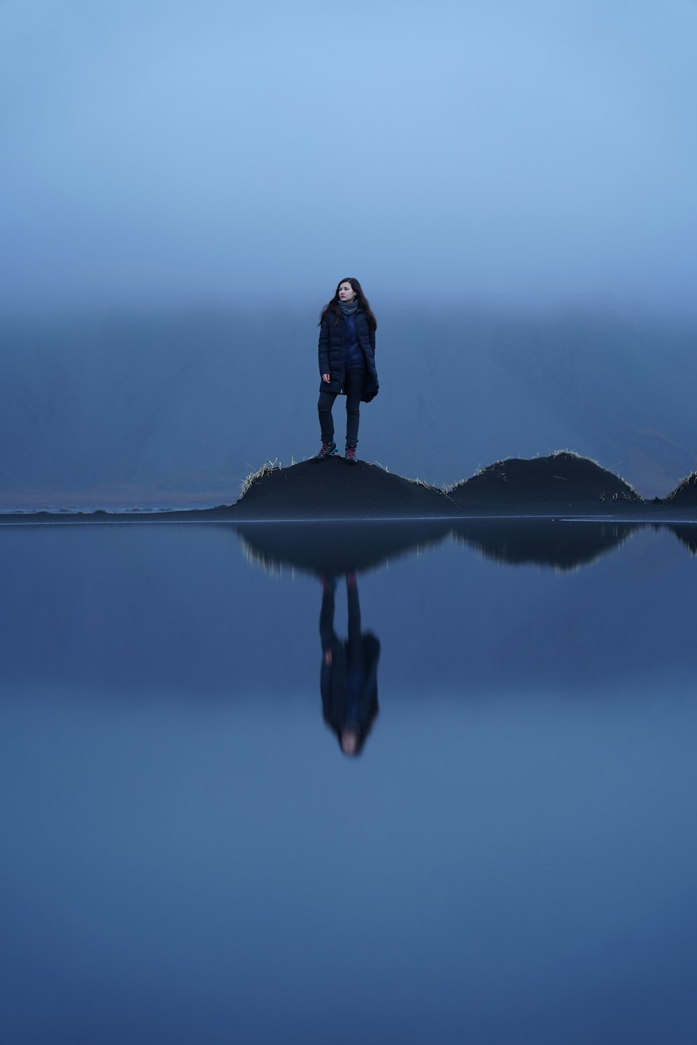 une personne debout sur un rocher dans l’eau