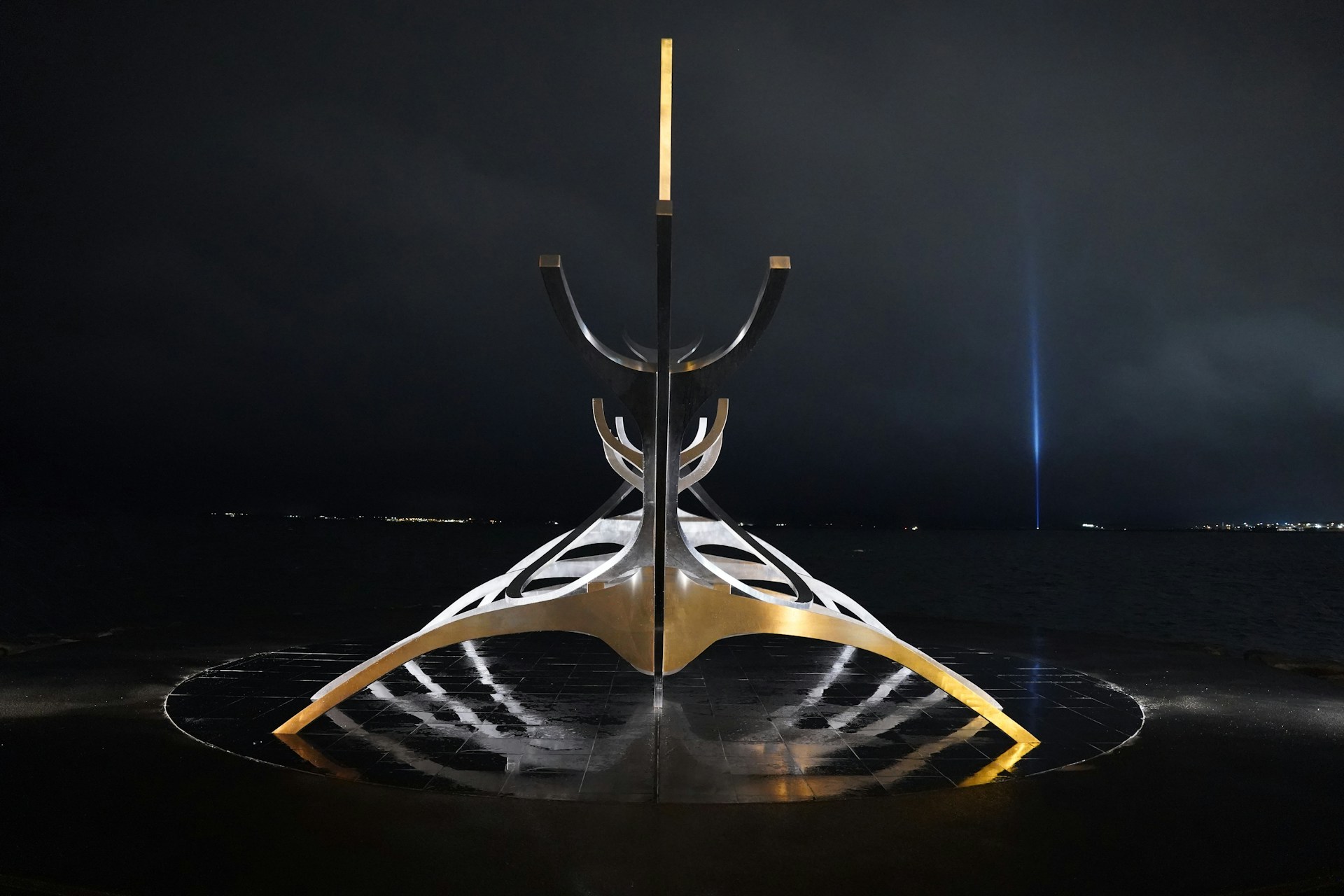 A striking sculpture blending metal and light, showcasing intricate technological details in a dark gallery setting.