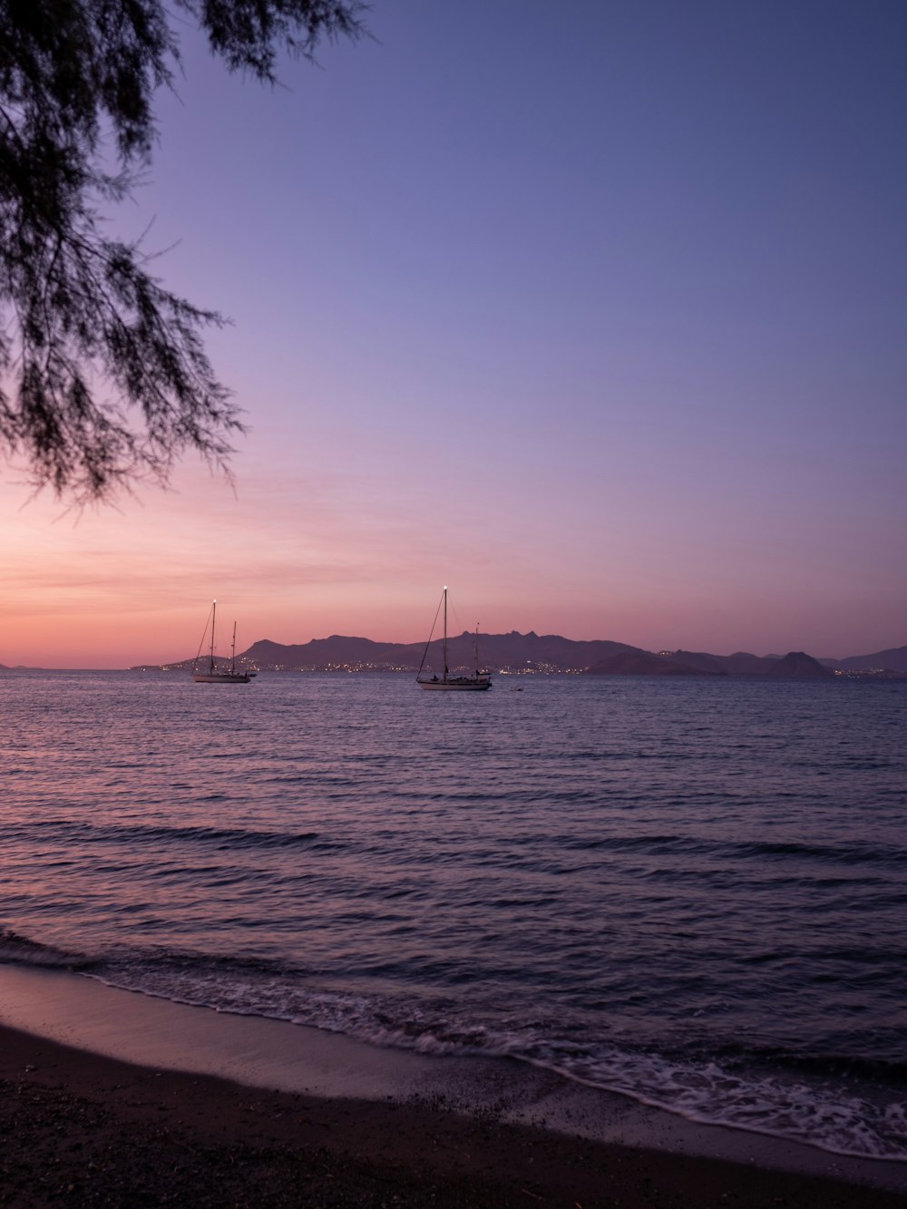 a beach with boats in the water