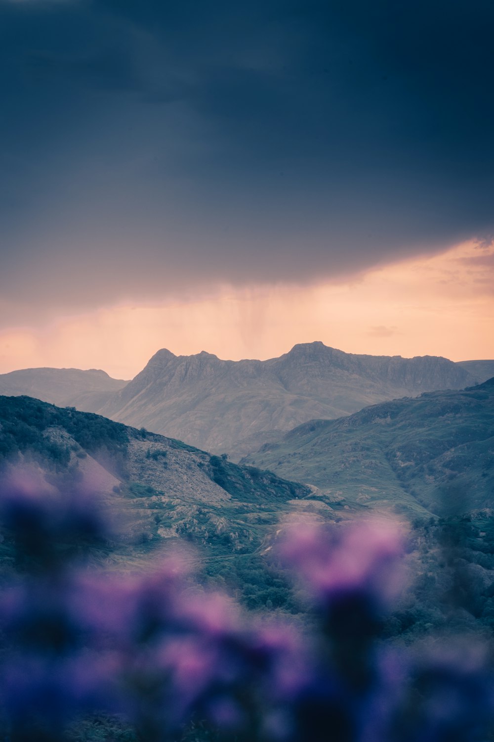 a mountain range with purple clouds