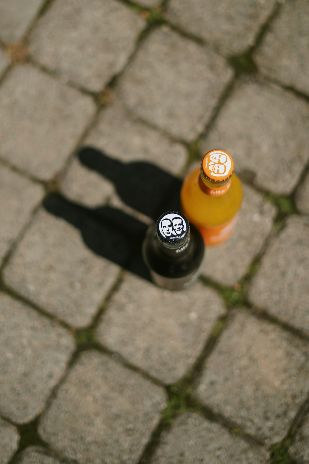 two bottles of alcohol on a stone surface