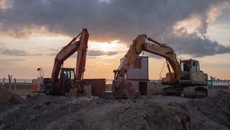 a few construction vehicles in a dirt field