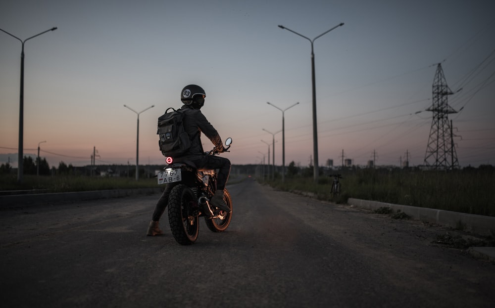 Un uomo che guida una motocicletta su una strada