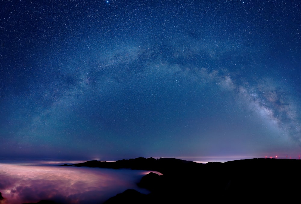 a starry night sky over a mountain range