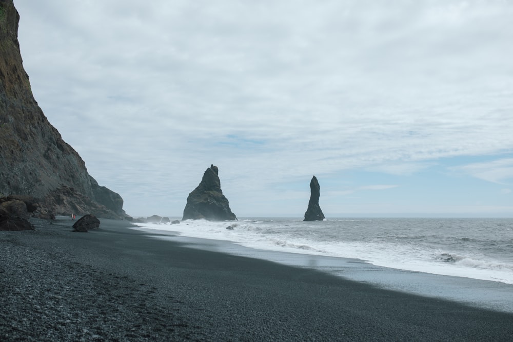 a rocky beach with a large body of water in the background