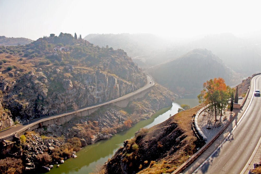 a road with a bridge over it and a body of water by it