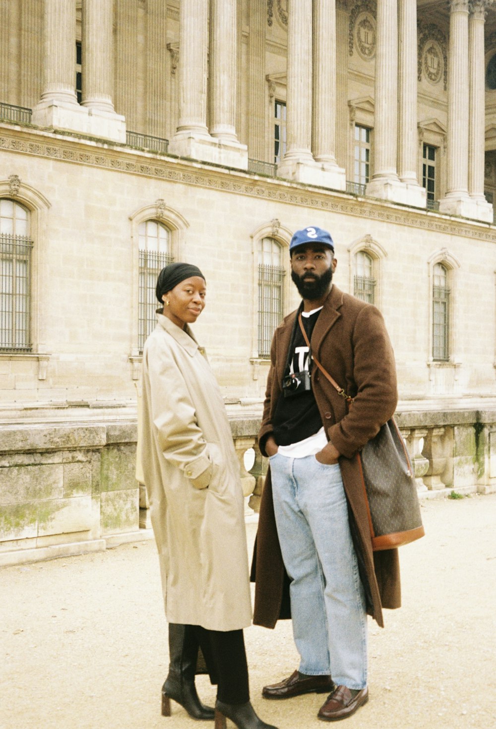 a man and woman posing for a picture in front of a building