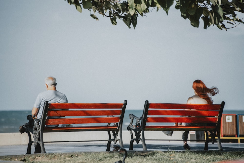 Una coppia seduta sulle panchine foto – Grigio Immagine gratuita su Unsplash