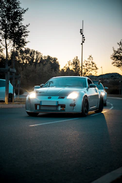 Sleek mach1 performance car hugging a winding mountain road at sunset.