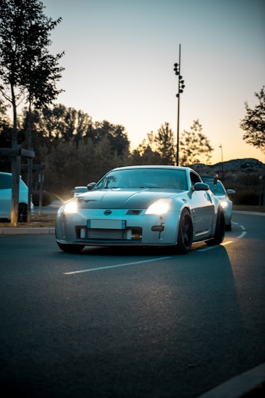 A sleek sports car on a winding road during sunset.