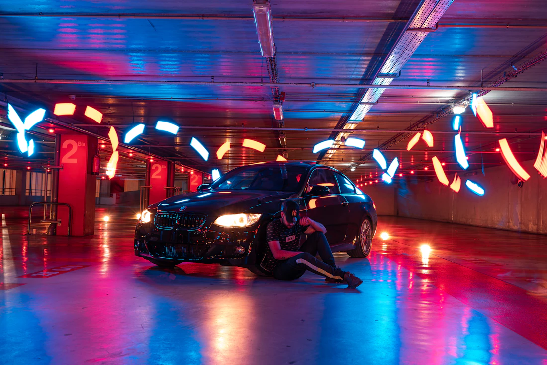 Detailing technician working beside a vehicle under studio light
