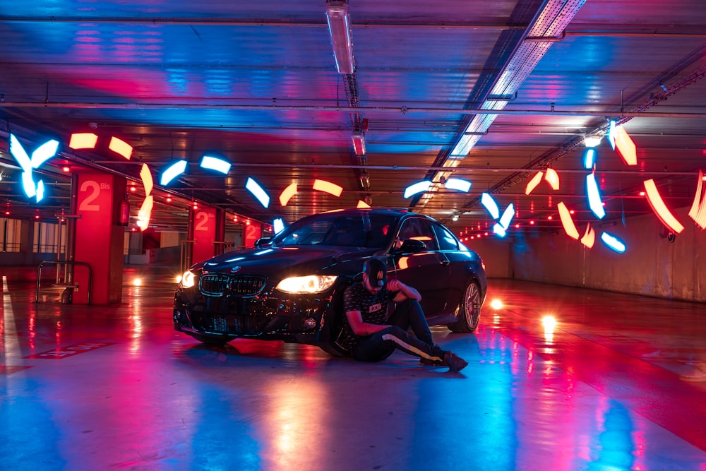 a person kneeling next to a car