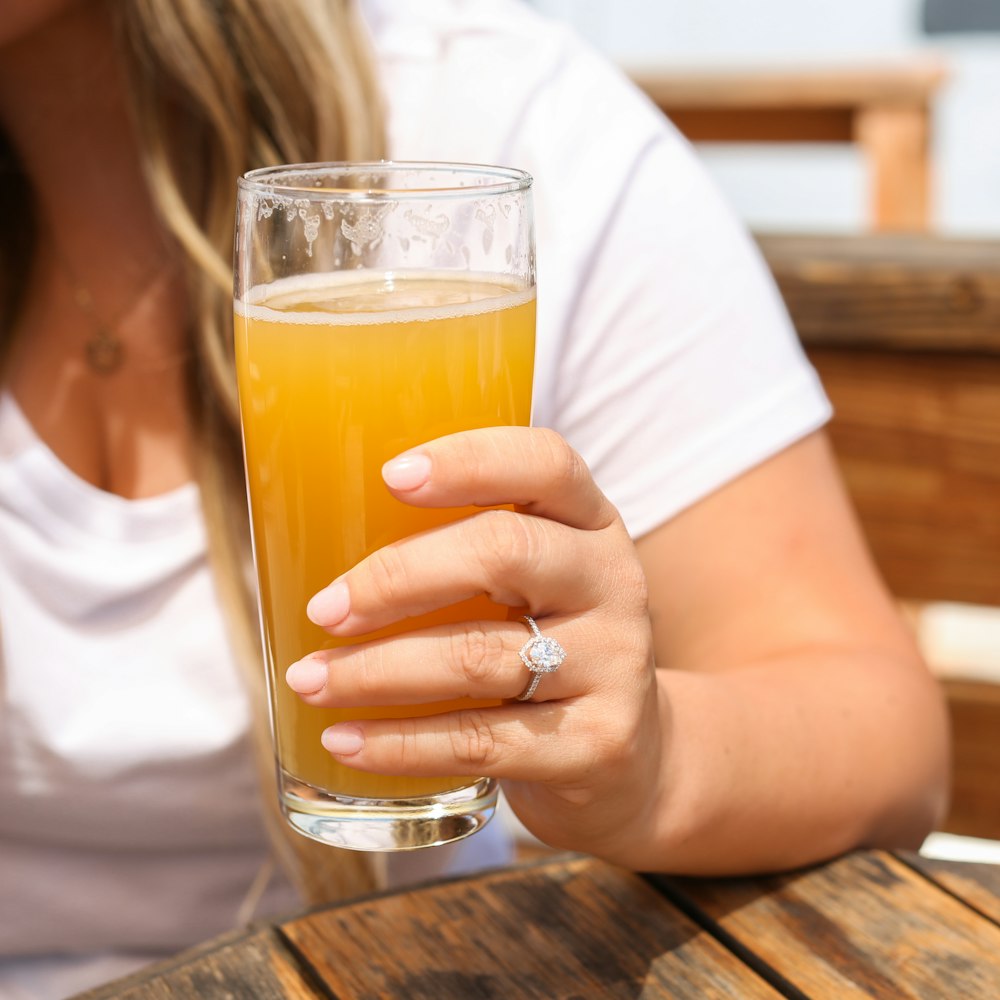 a person holding a glass of beer