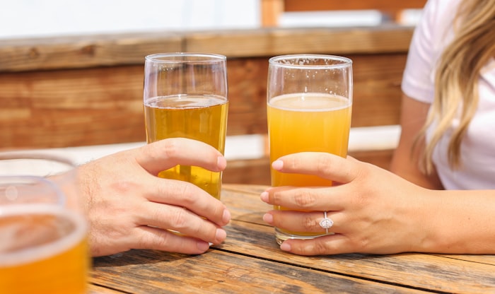Two friends toasting golden pints on a wooden table