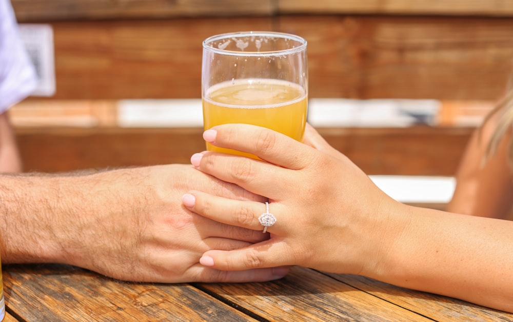 a person holding a glass of liquid