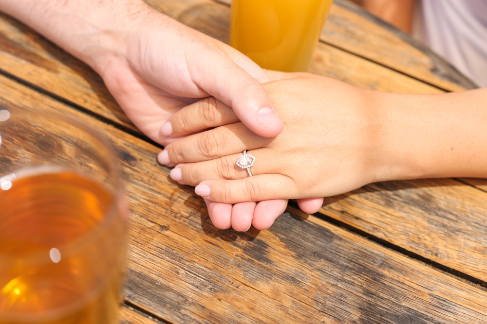 Un couple de mains tenant un verre de bière