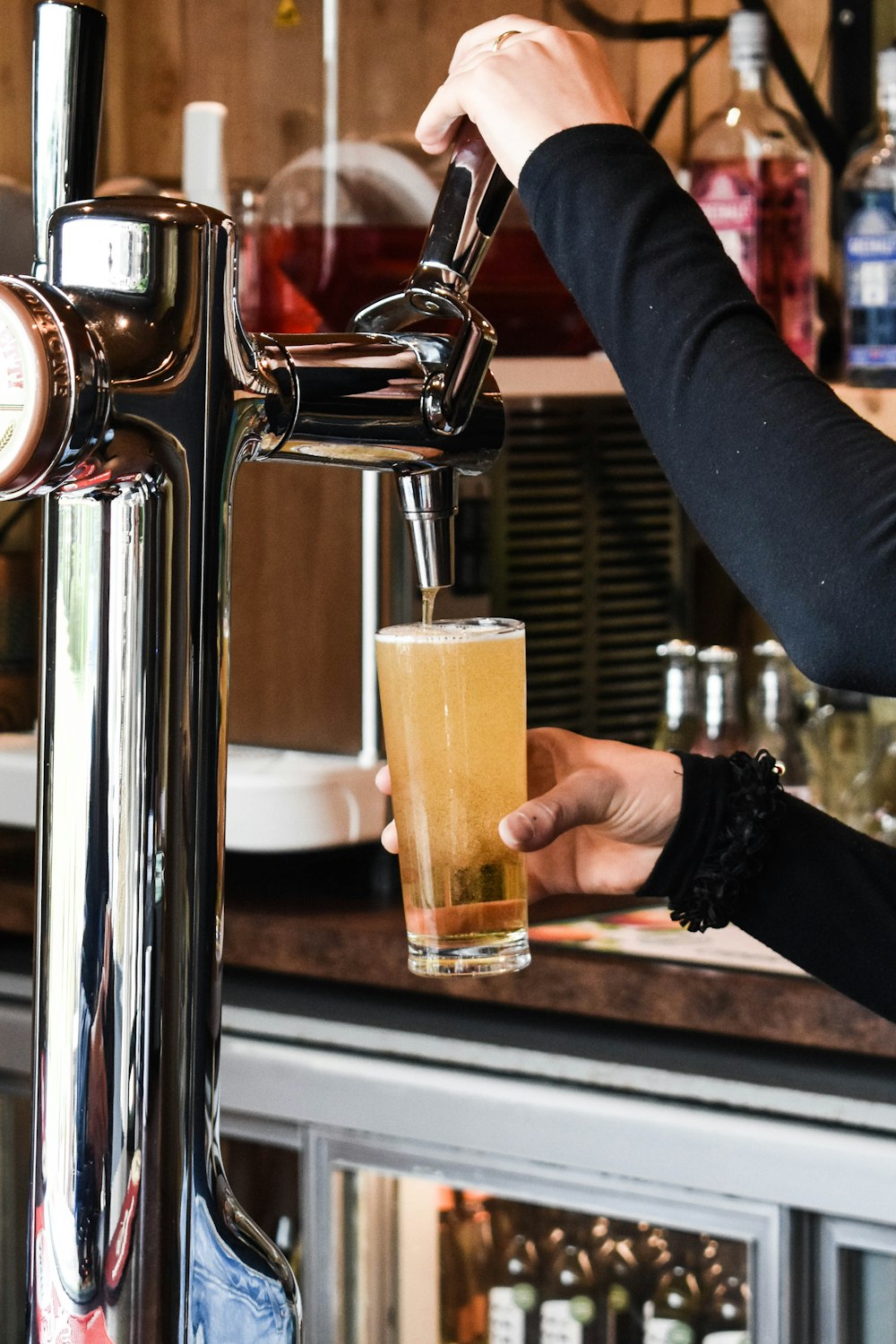 a person pouring a drink into a glass