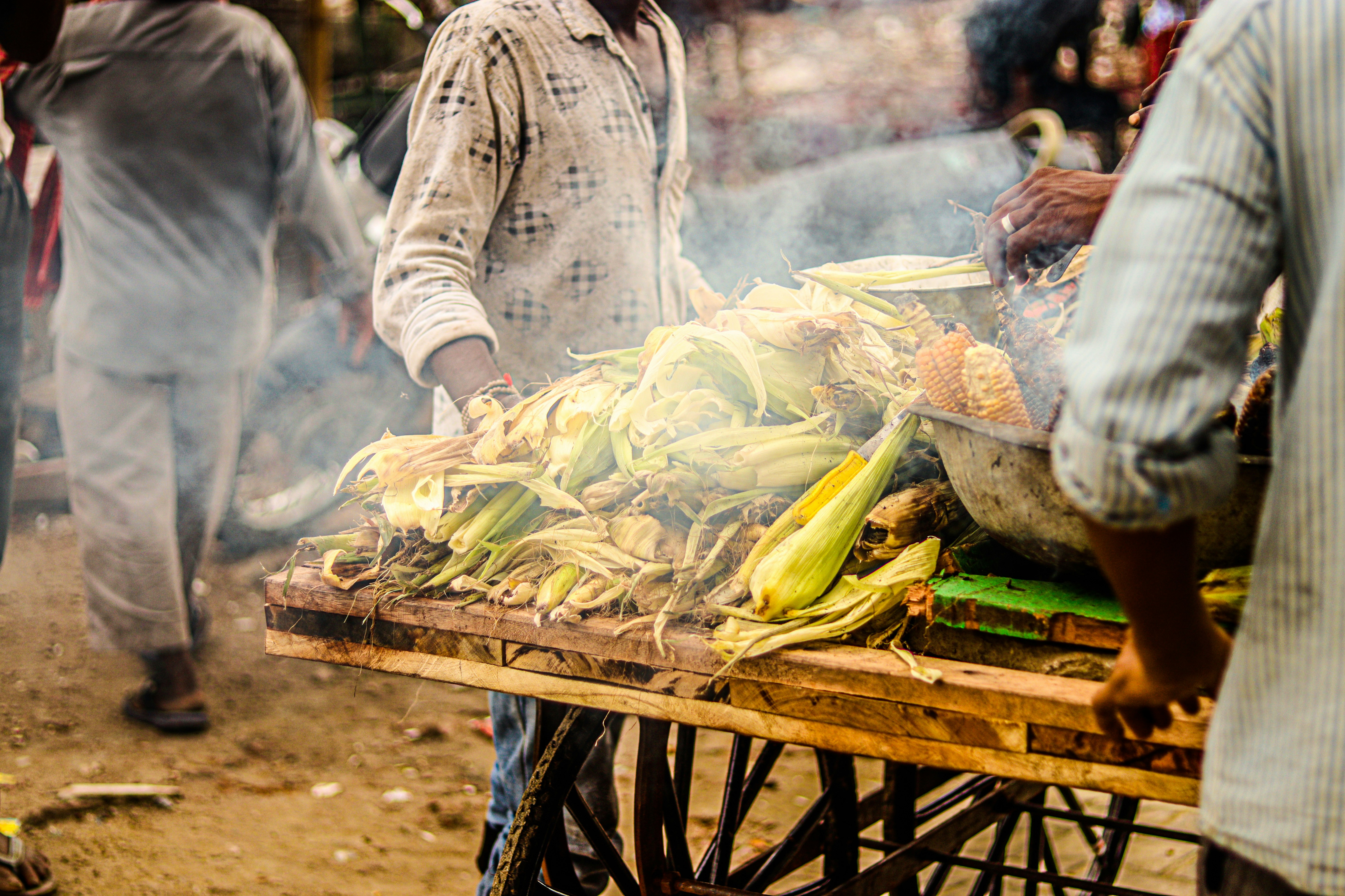 a group of people standing around a table full of bananas