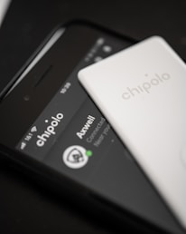 Close-up of a smartphone displaying Automile Track’s mobile app with active vehicle tracking.