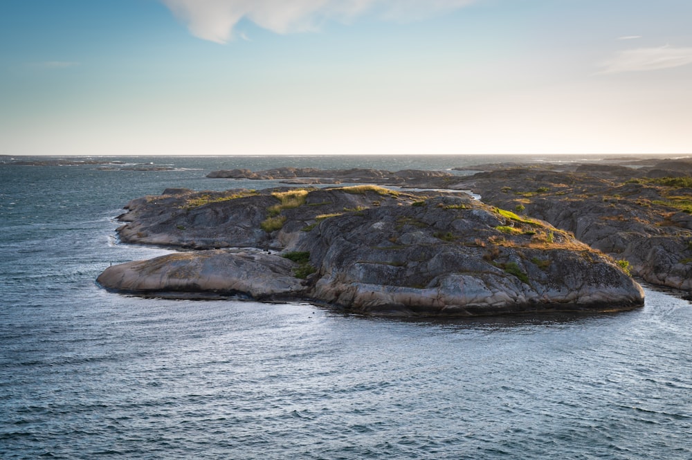 a rocky shoreline with a body of water in the background