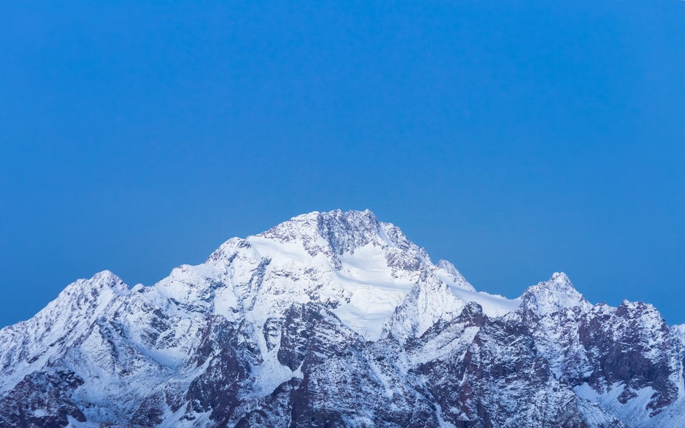 a snowy mountain with blue sky