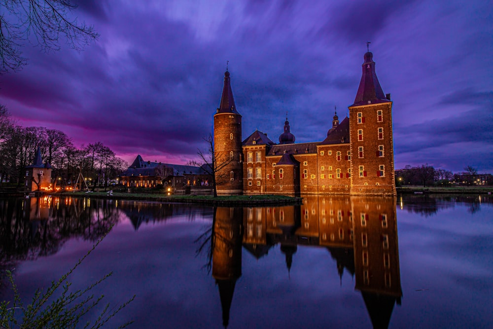 a castle with a moat and a body of water in front of it