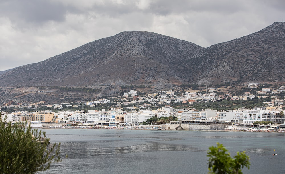 a city next to a body of water with a mountain in the background