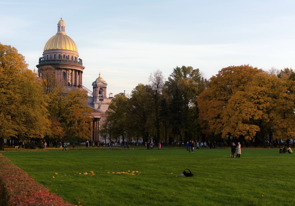 a large green park with a domed building in the background