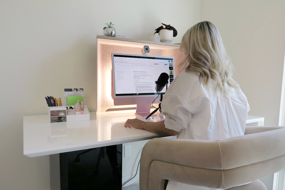 a woman sitting at a desk with a computer