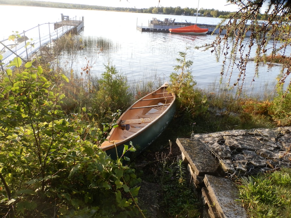 a boat sits on the shore of a lake