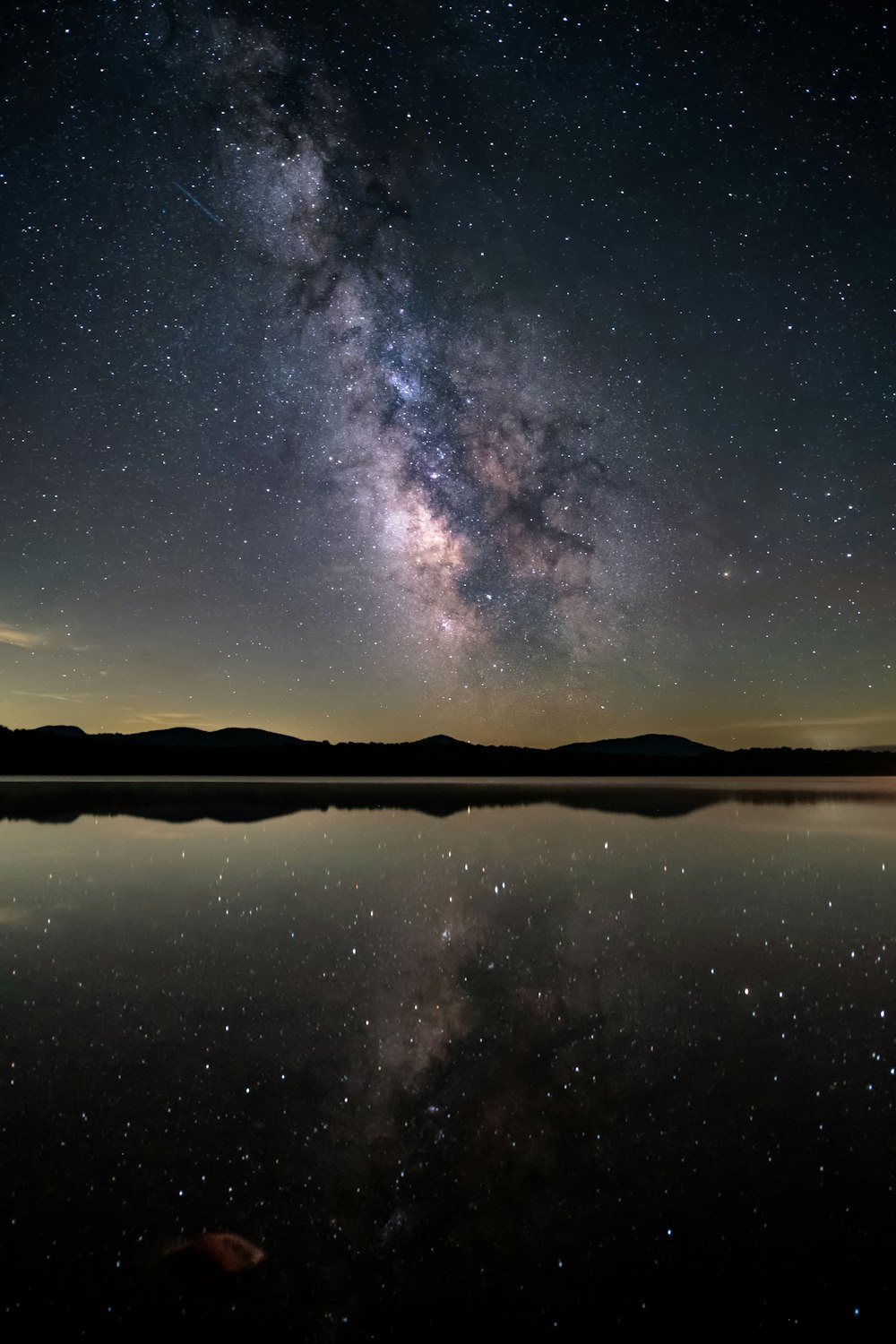 uno specchio d'acqua con un cielo stellato sopra di esso