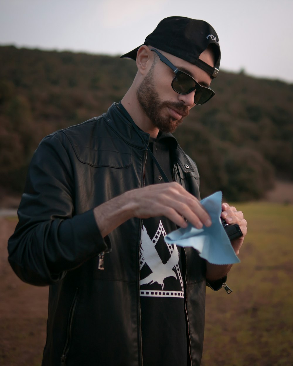 a man wearing sunglasses and a hat holding a book