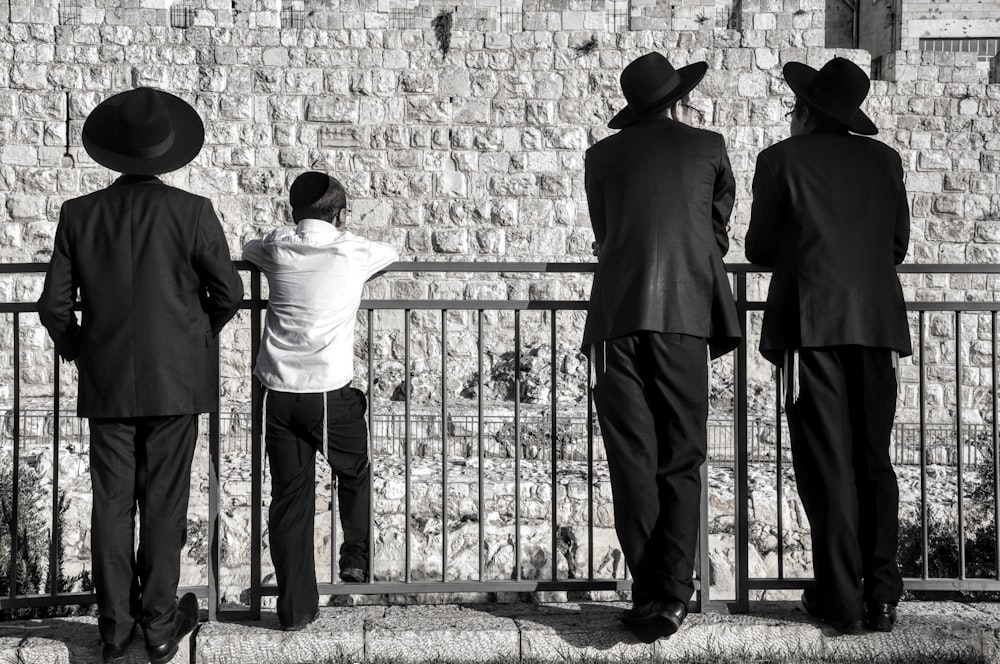 a group of people standing by a fence