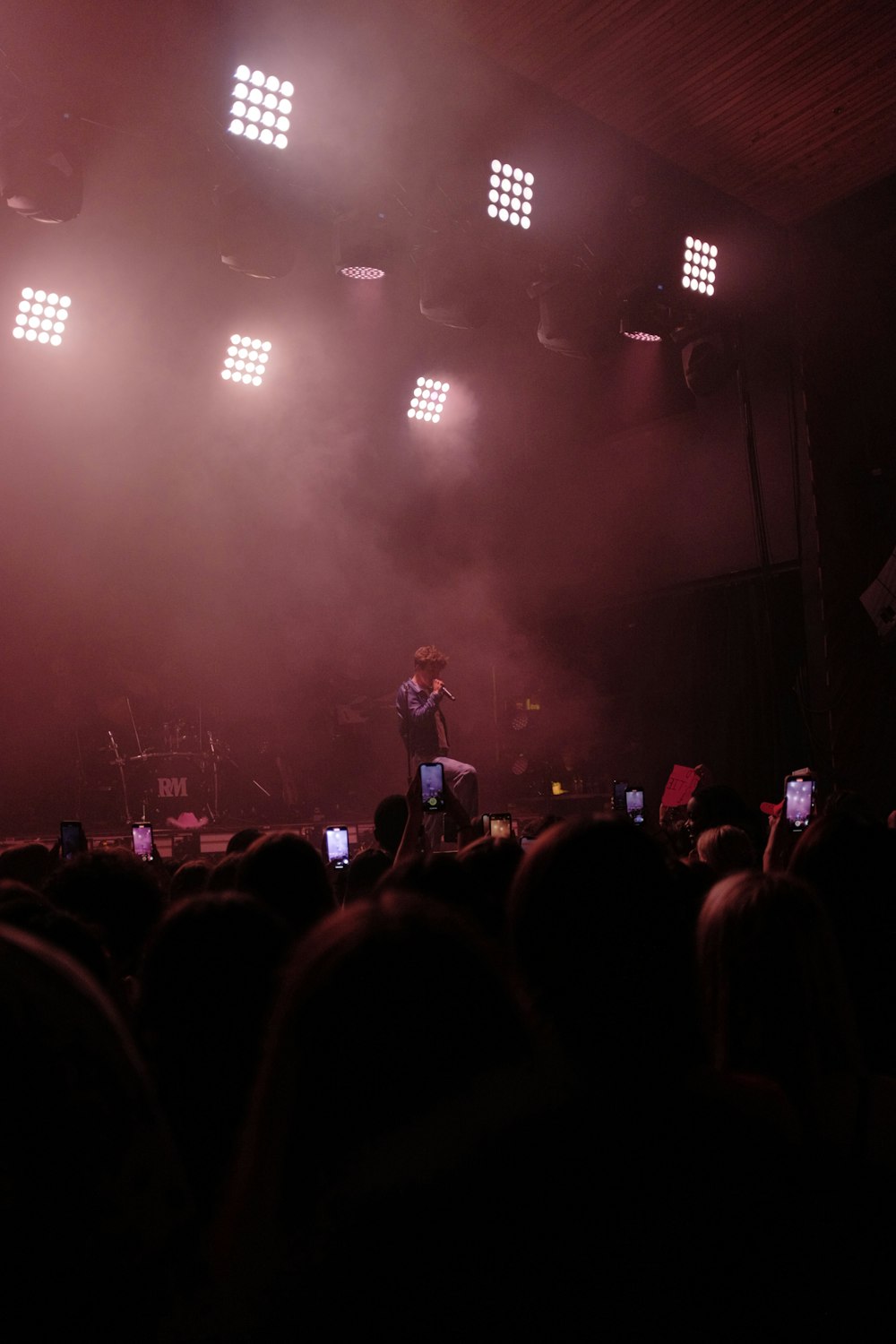 a person on a stage with a crowd watching
