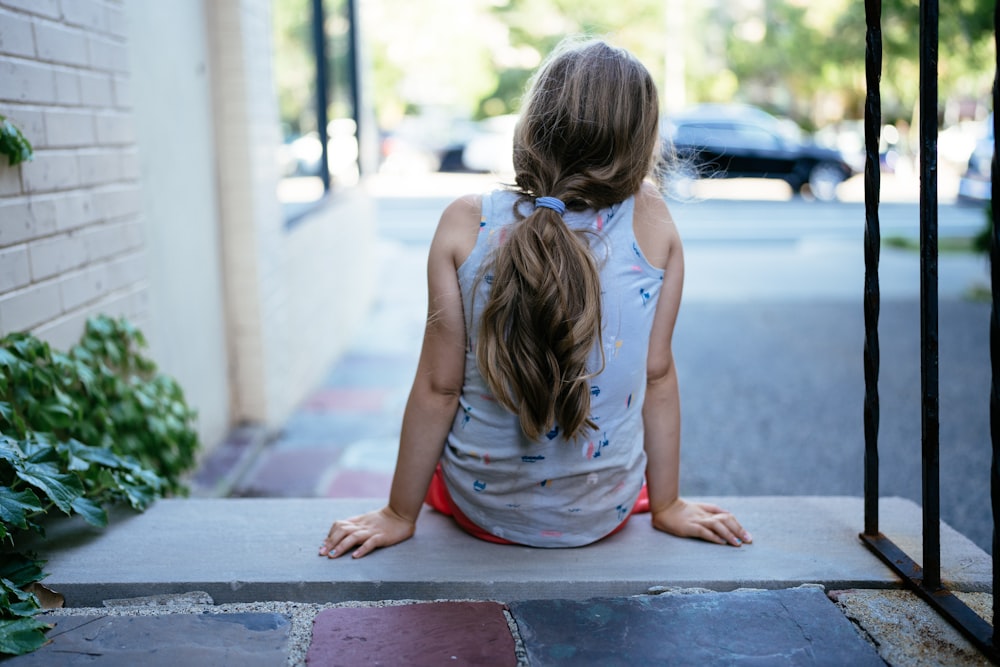 a person sitting on a sidewalk