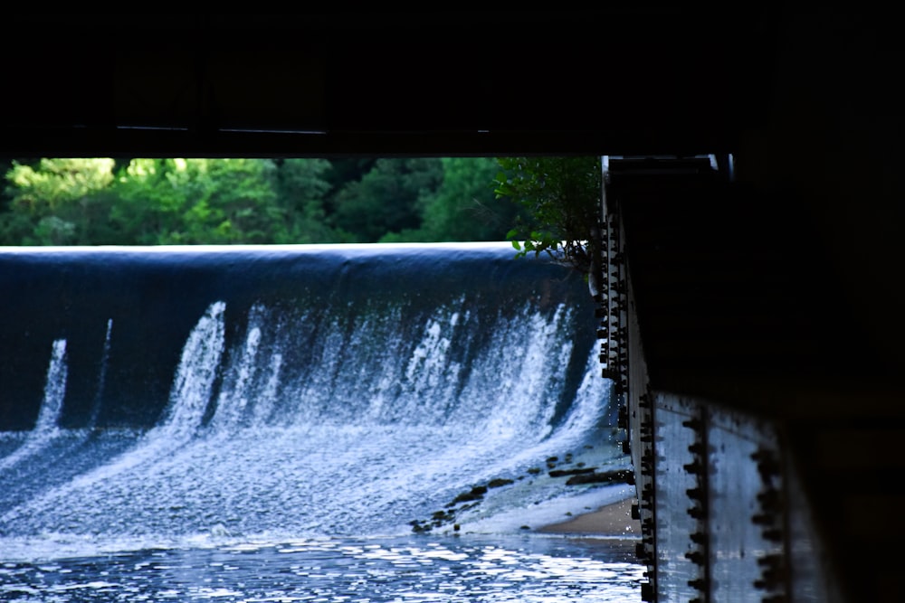 a large waterfall with trees in the background