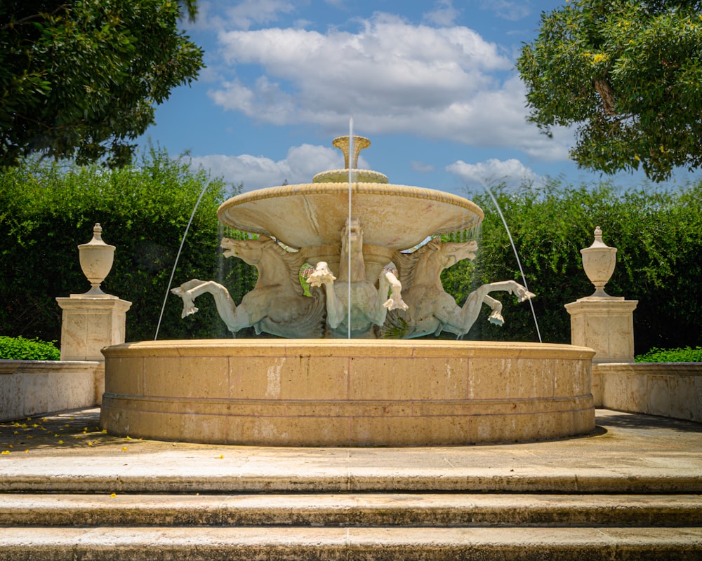 a fountain with statues and a cross