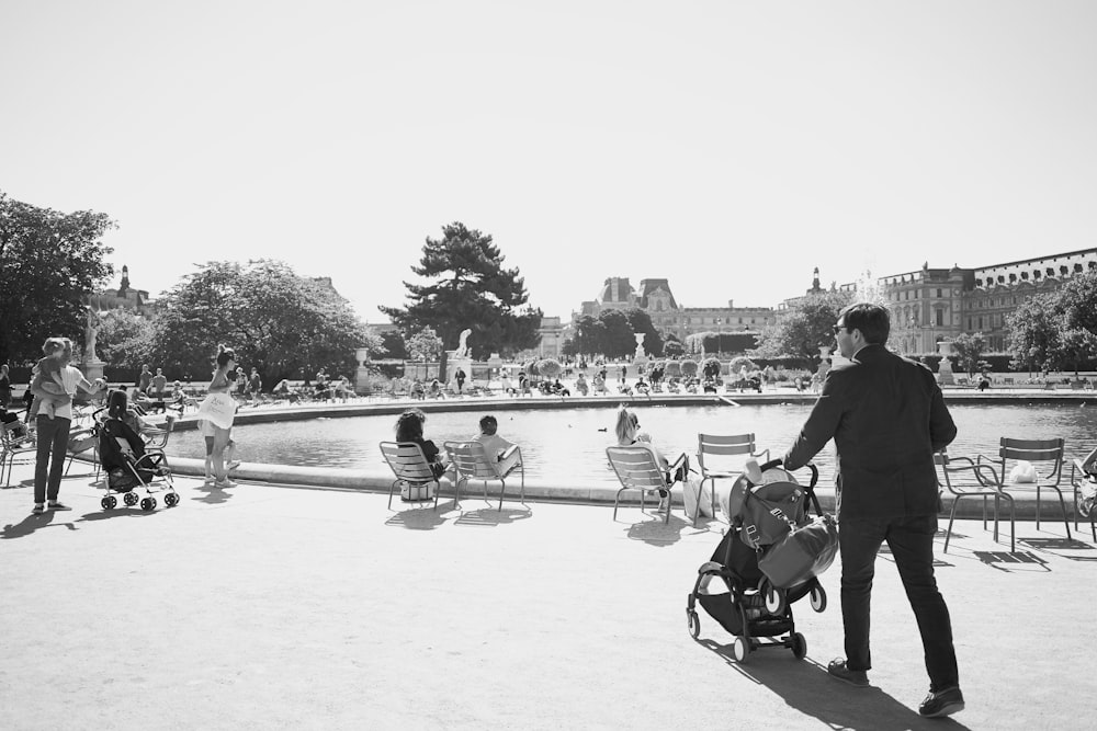 a group of people sitting on chairs by a lake